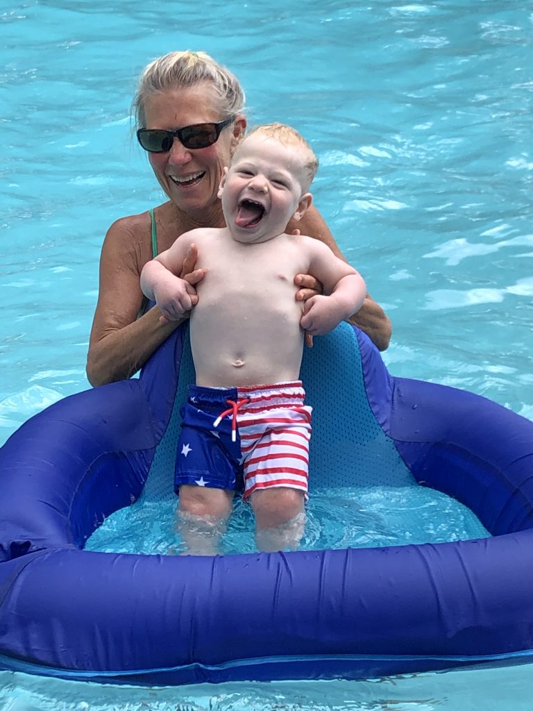 Woman and toddler playing in a swimming pool.